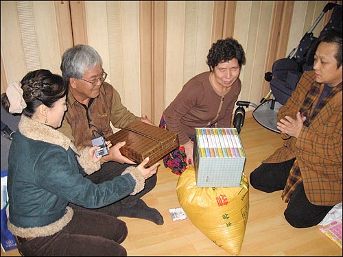 쌀과 함께 희우가 읽을 책 '삼국지 10권' 을 전해준데 이어 김수양 리포터가 할머니 할아버지 내복을 건네고 있습니다. 